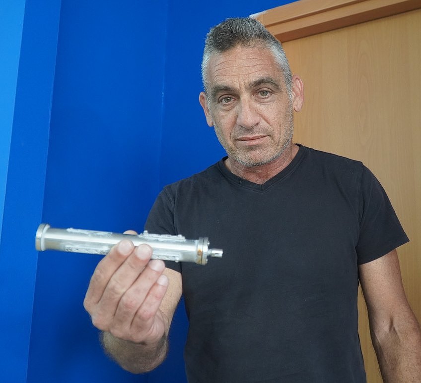 Omer Hiram displays the RC vehicle's aluminum fuel pod, designed for safe and easy transportation